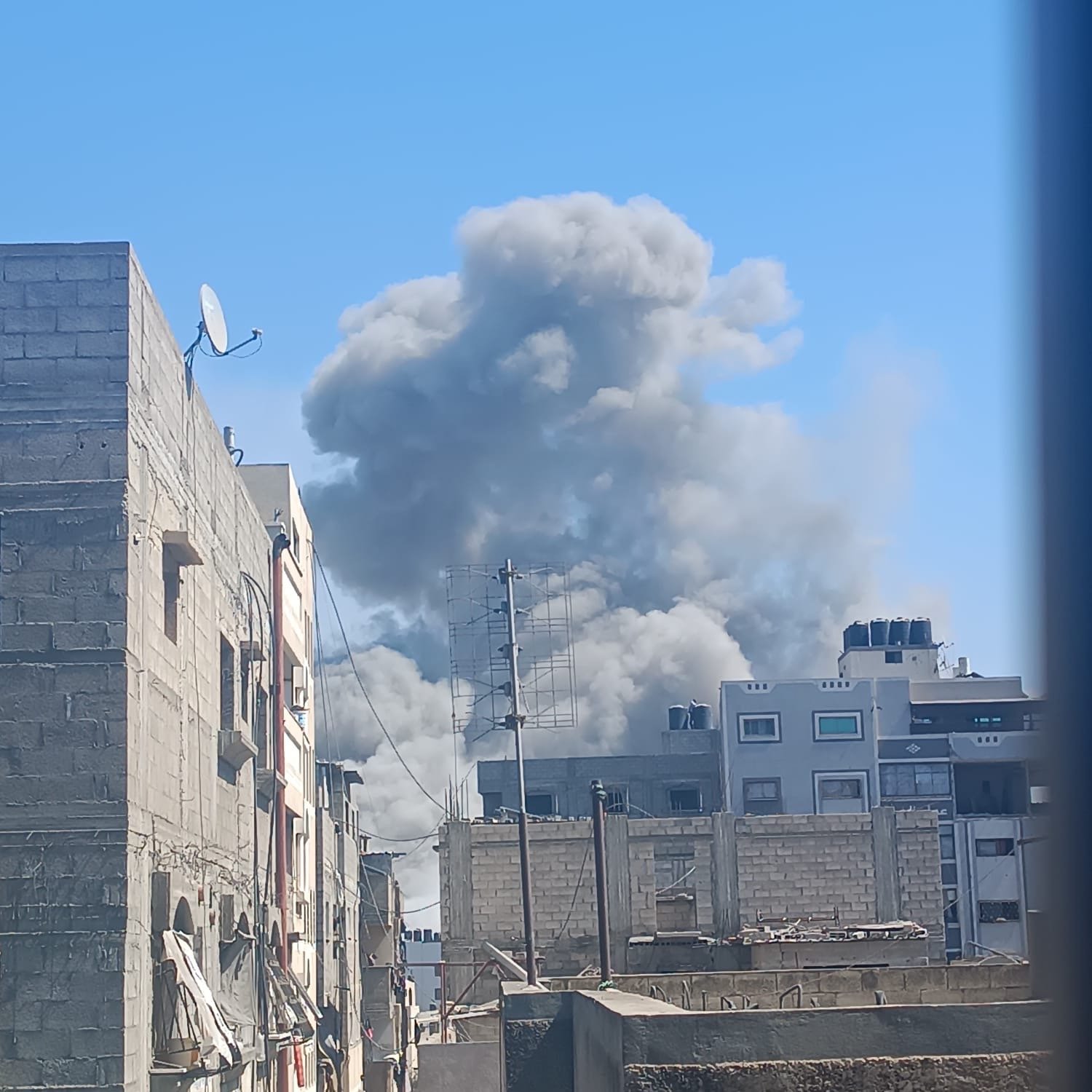 Courtesy of Tariq’s family. Smoke rises above Gaza buildings after bombardment; tied to Help Gaza family evacuate