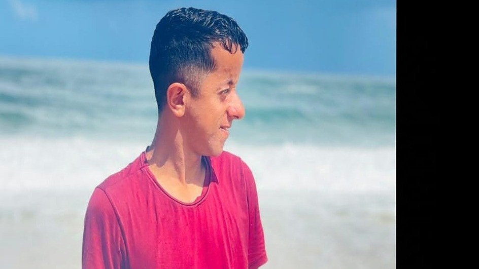 Courtesy of Hakim’s family. Hakim at Gaza shoreline; tied to Help Gaza family shelter.